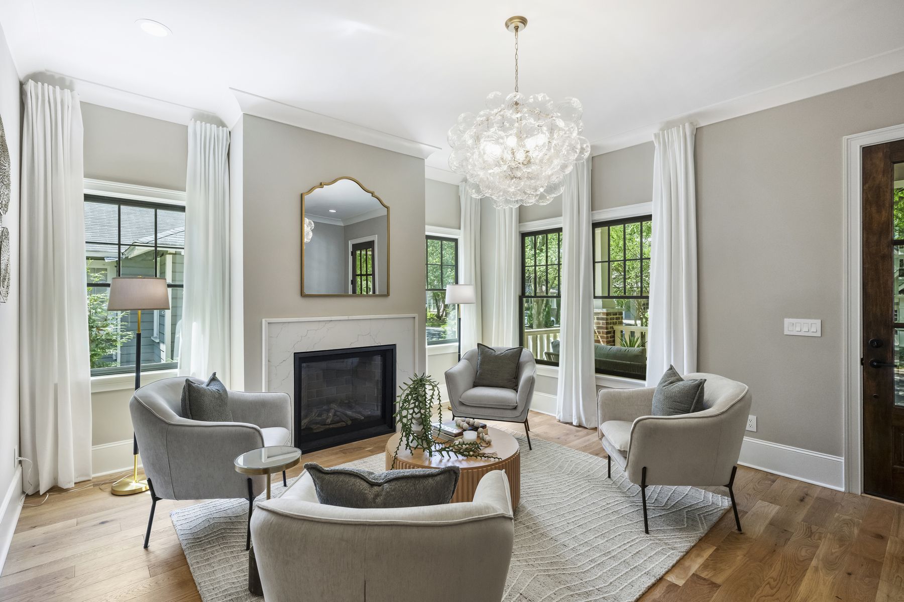 Formal living room with a white marble fireplace and a sculptural chandelier