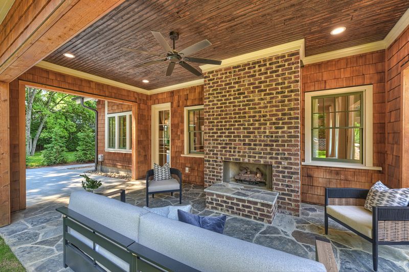 Covered patio with a brick outdoor fireplace