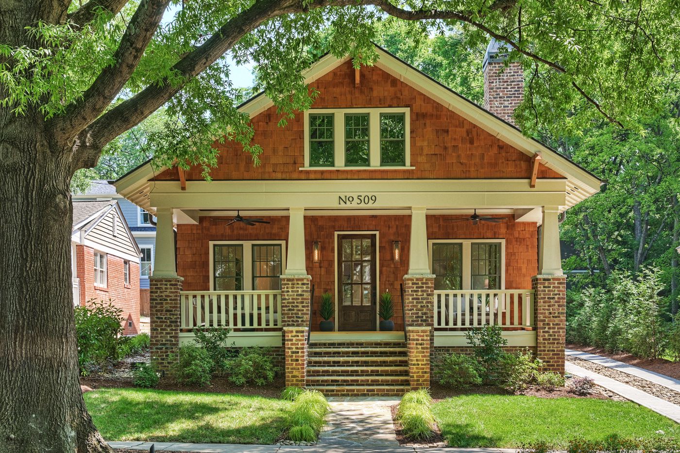 The brick-and-cedar Craftsman front of 509 E Tremont Avenue