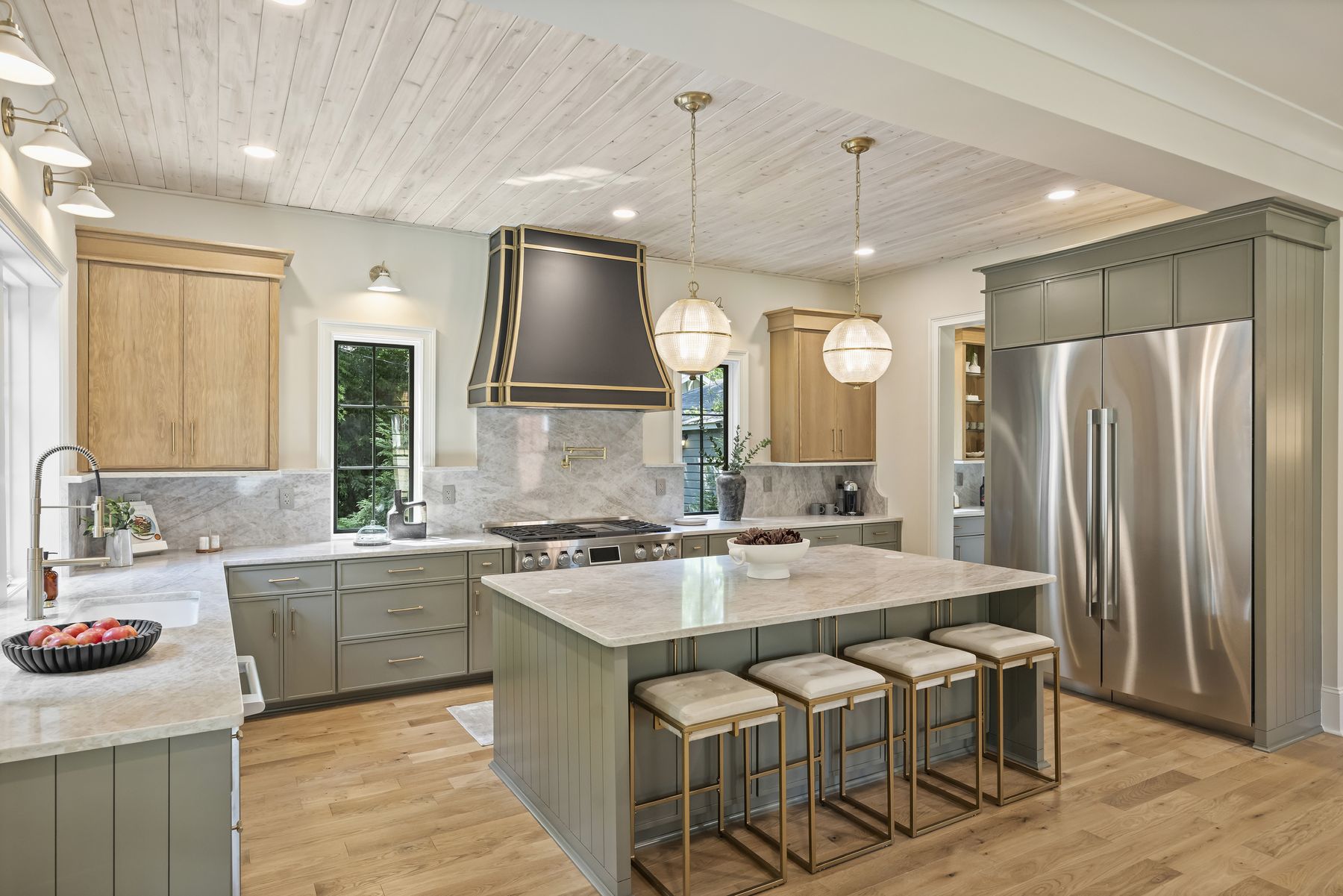 Chef's kitchen with a custom range hood, quartz island, and professional appliances
