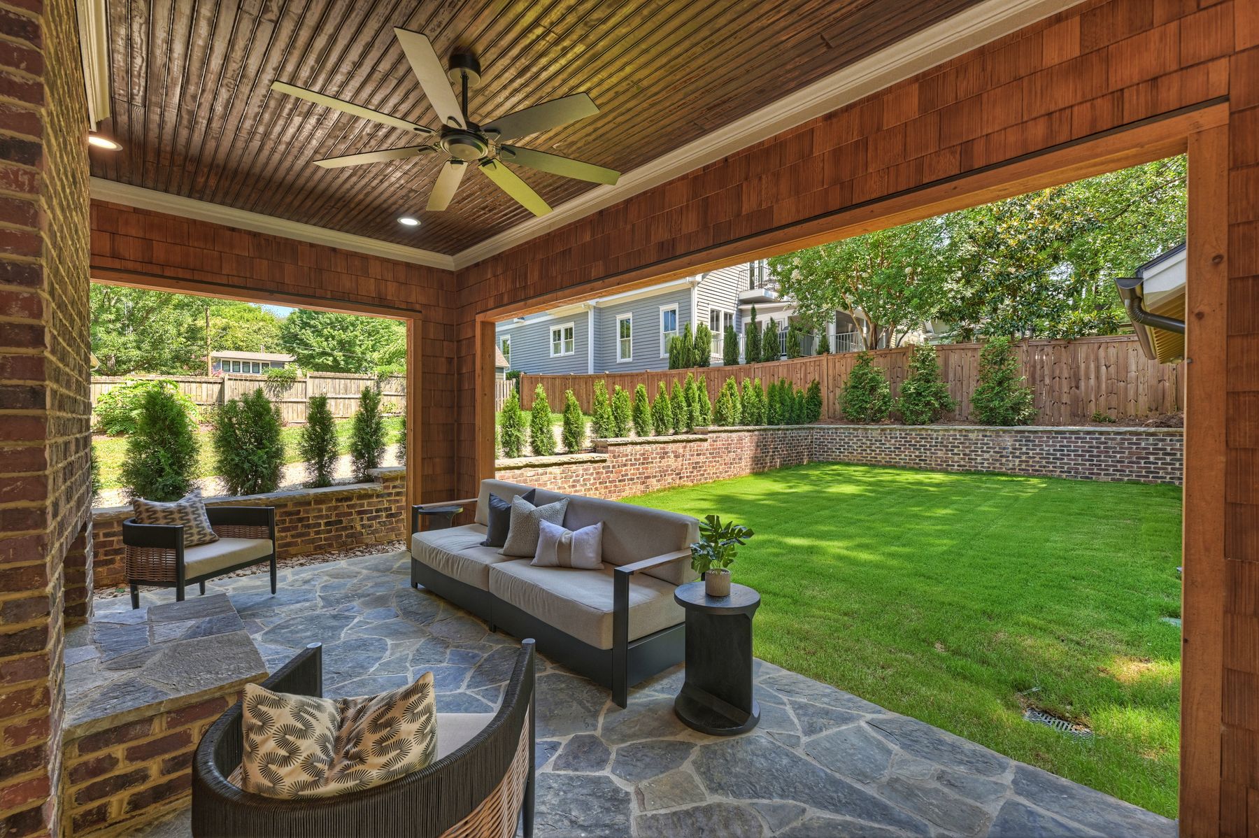 Covered patio looking out over the landscaped backyard lawn