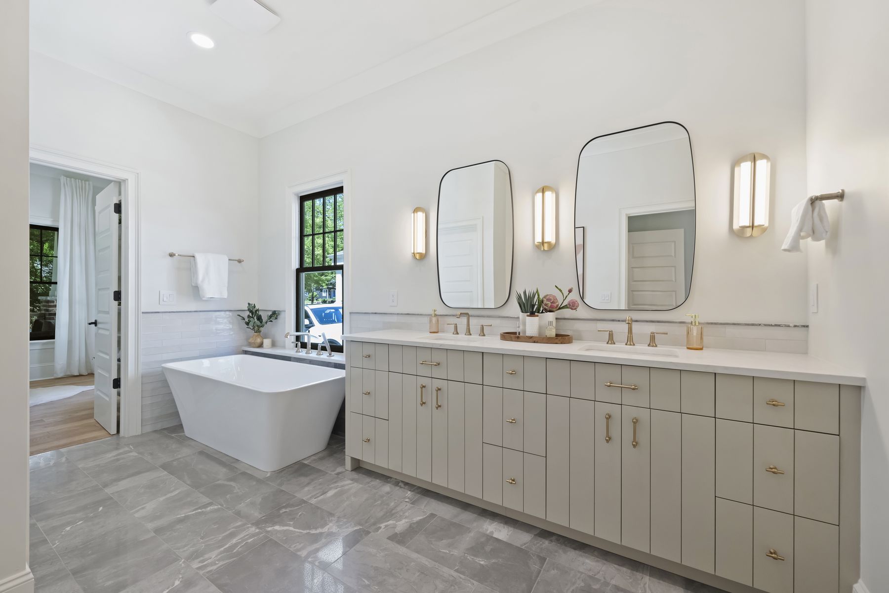 Primary bath with a freestanding tub and a long double vanity